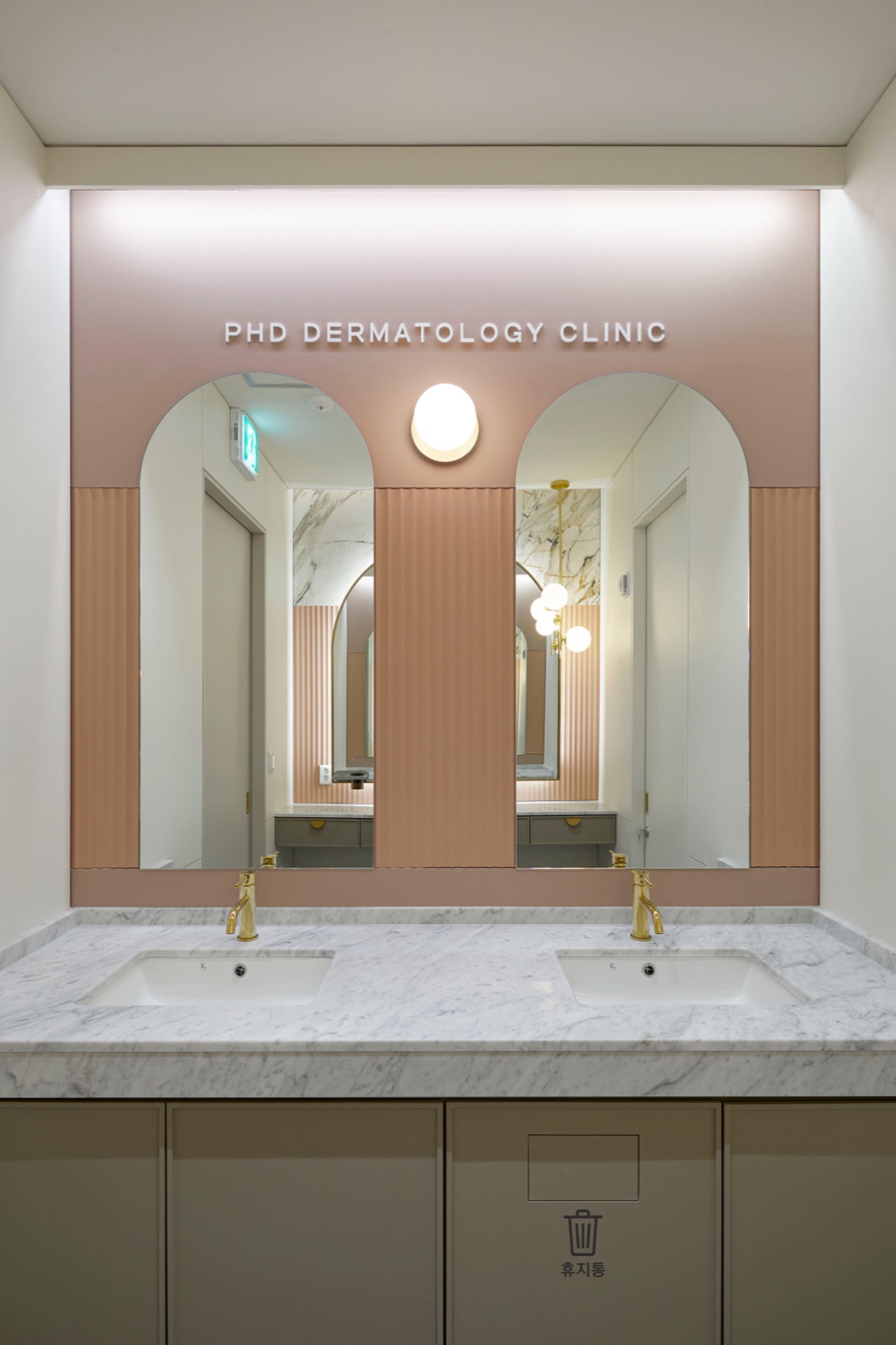 Vanity area with arched mirrors and PHD Dermatology Clinic lettering