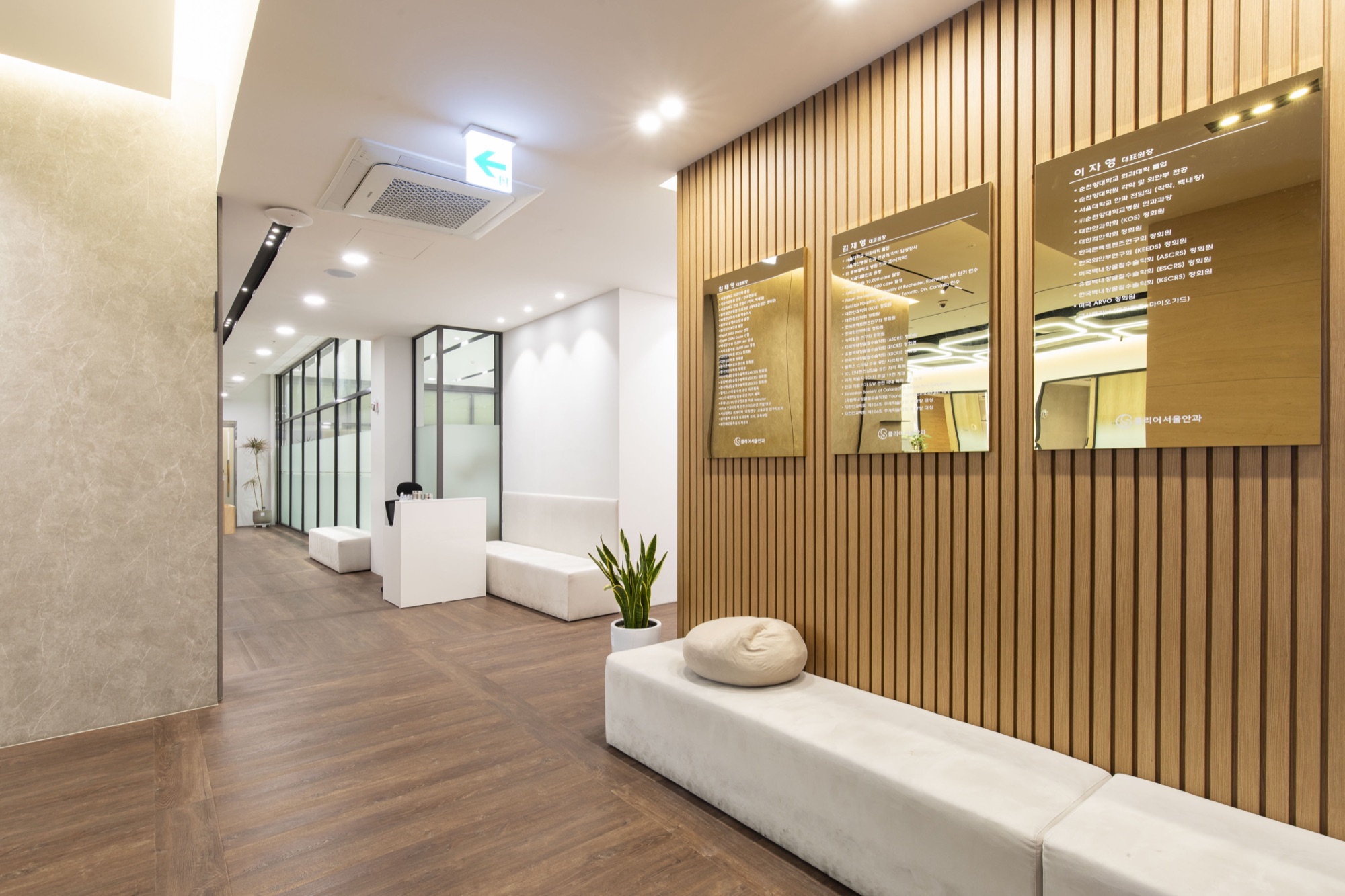 Corridor with wood-slat walls and glass-partitioned rooms