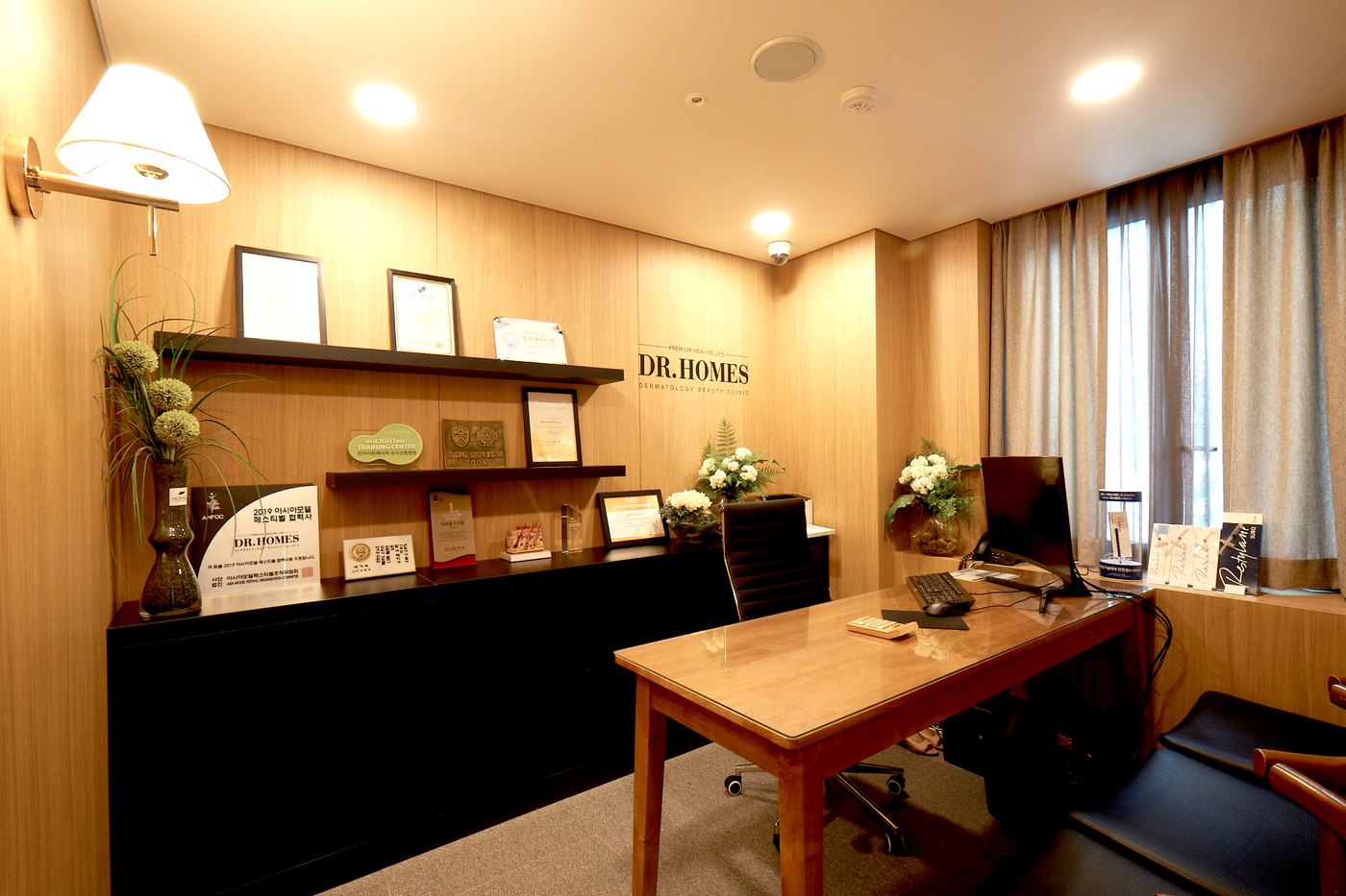 Consultation desk with wooden shelving and framed certificates behind it