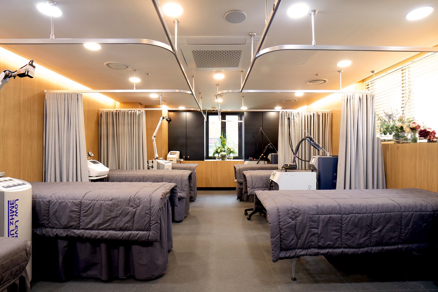 Treatment bays separated by curtains, each with its own bed and equipment trolley