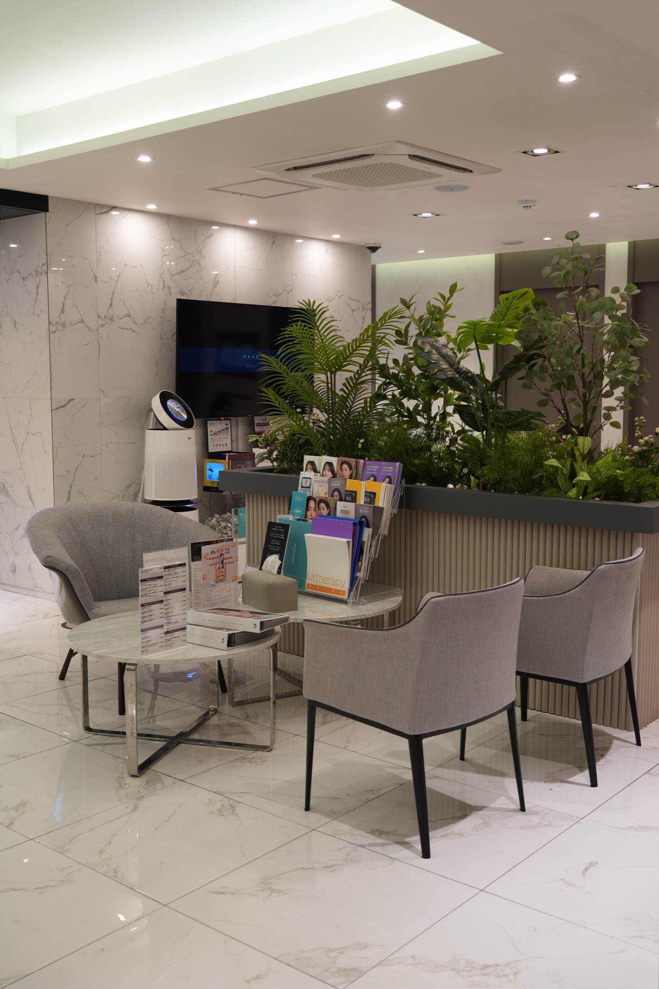 Lounge area with gray chairs, a magazine rack and a planter