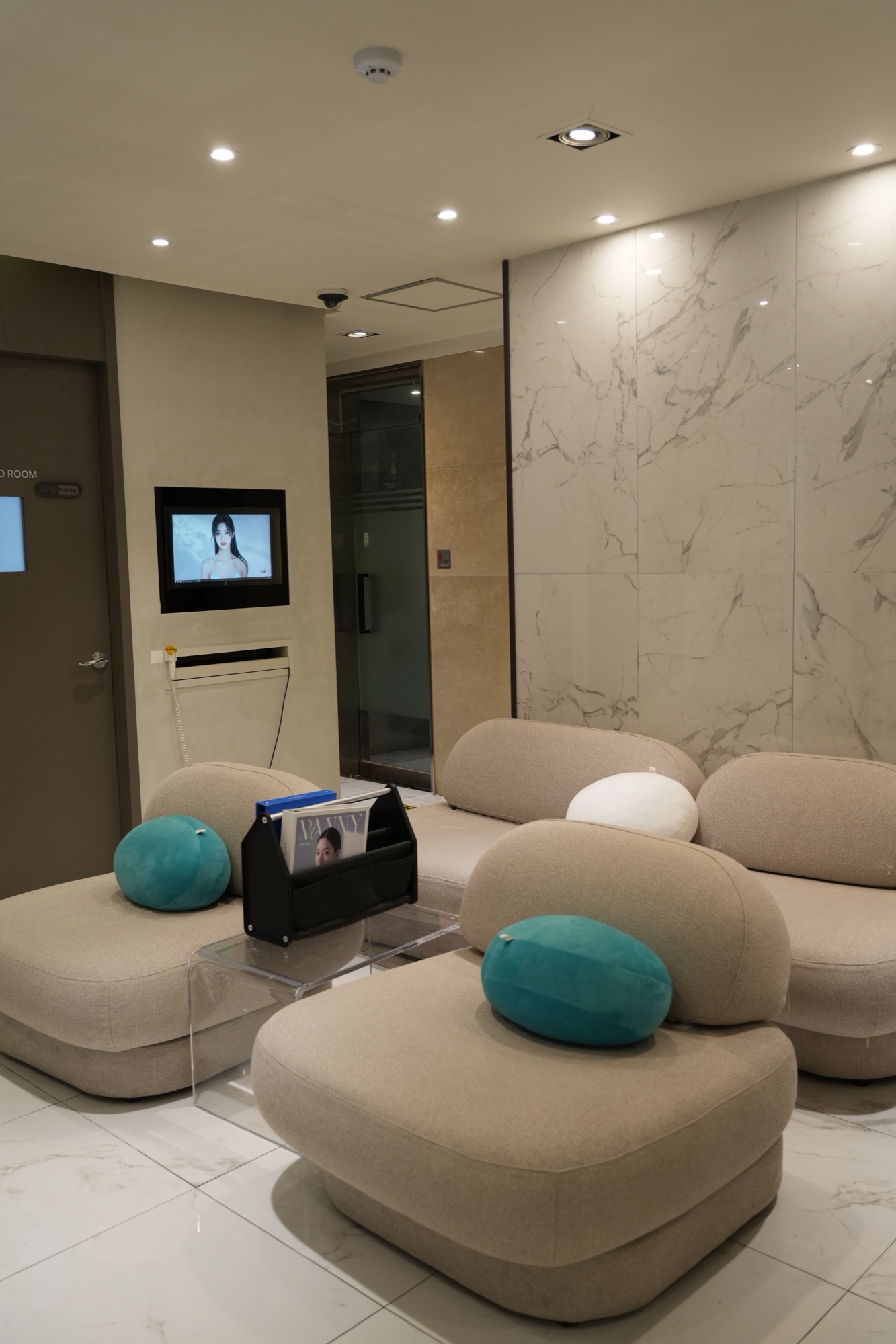 Waiting area with rounded beige sofas and teal cushions