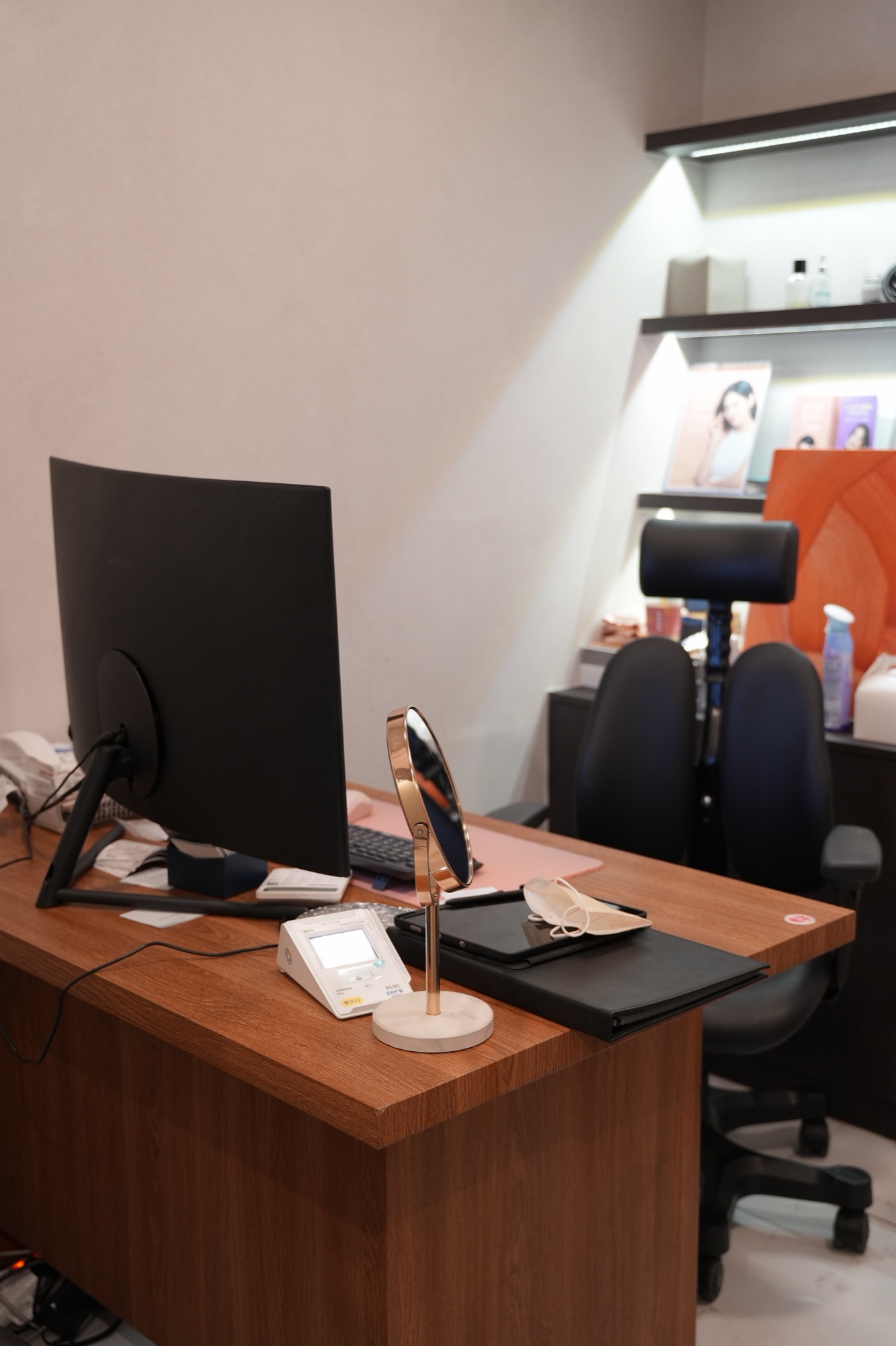 Consultation room with a desk, monitor and wall shelves