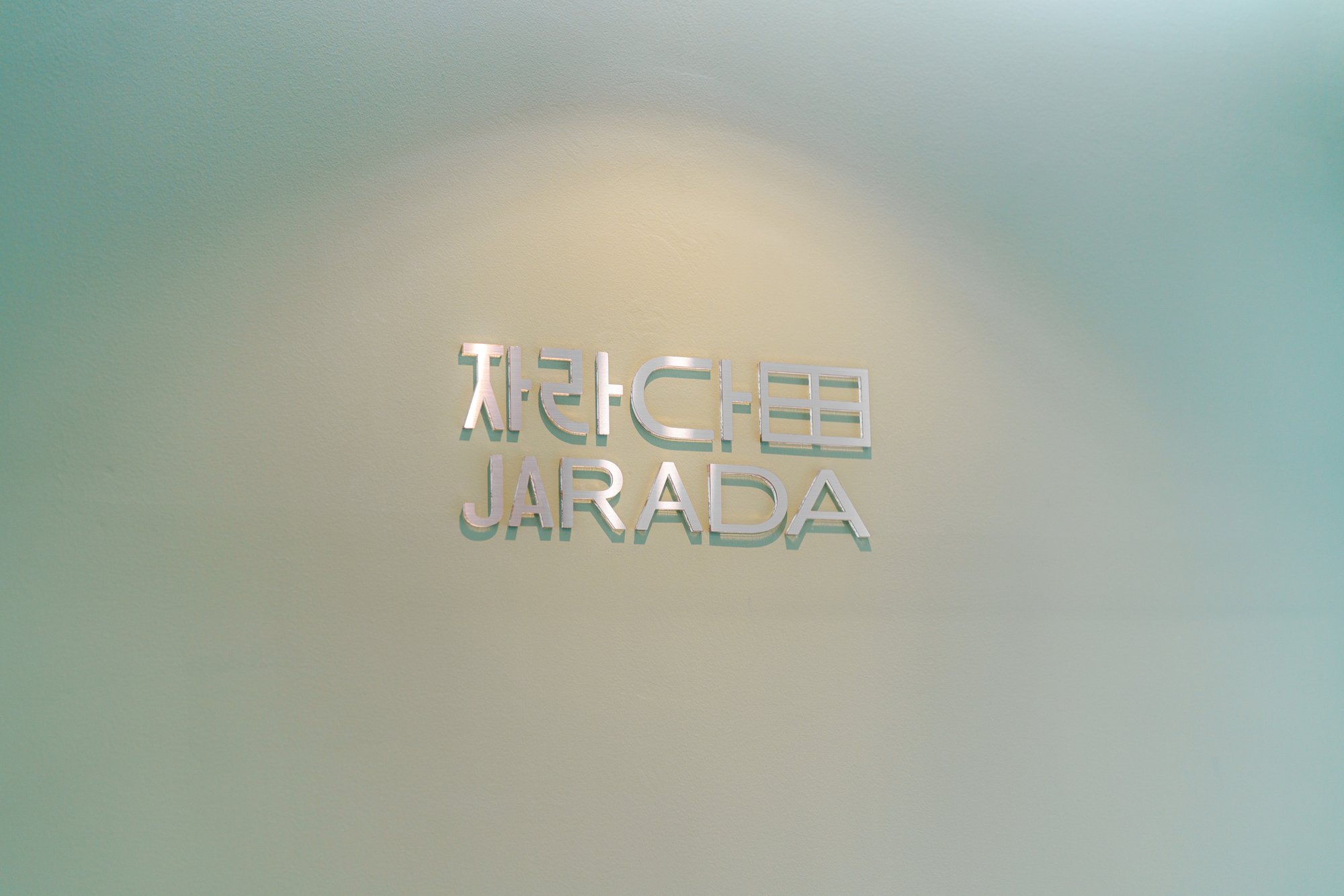 The JARADA wordmark etched into frosted glass inside the clinic