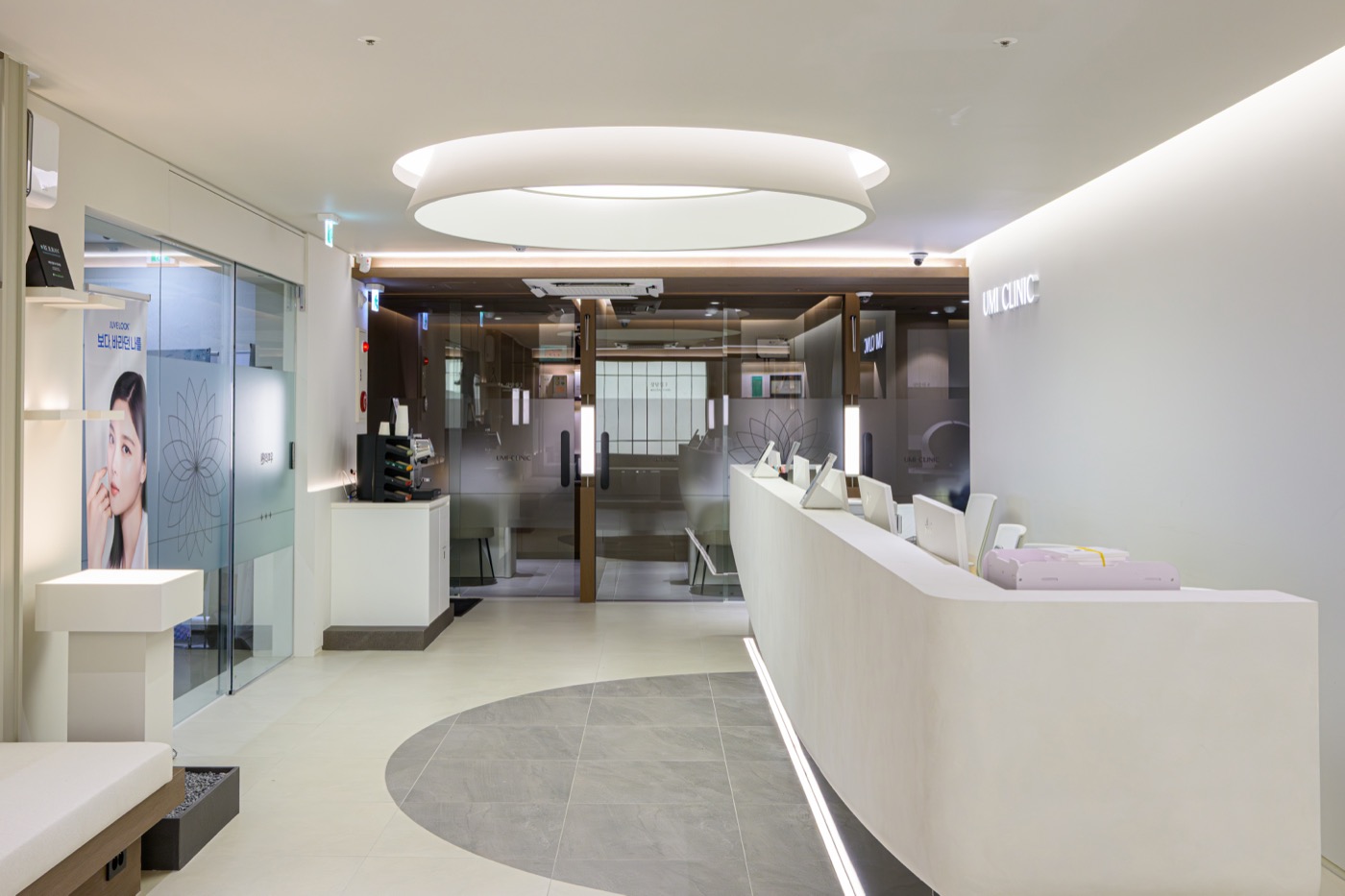 Lobby with a circular ceiling light, a curved reception counter and a seating area beyond