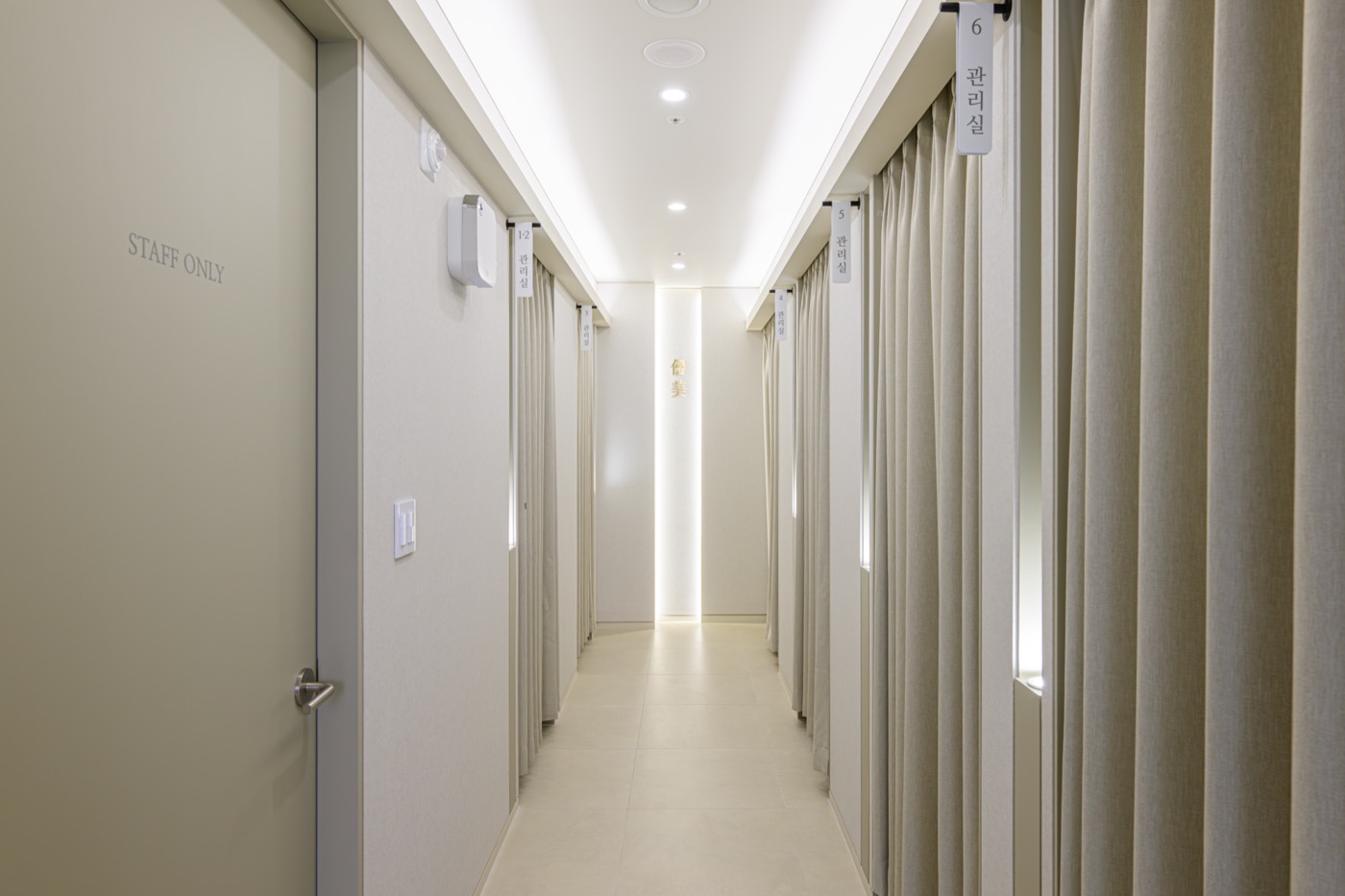 Corridor lined with curtained treatment bays
