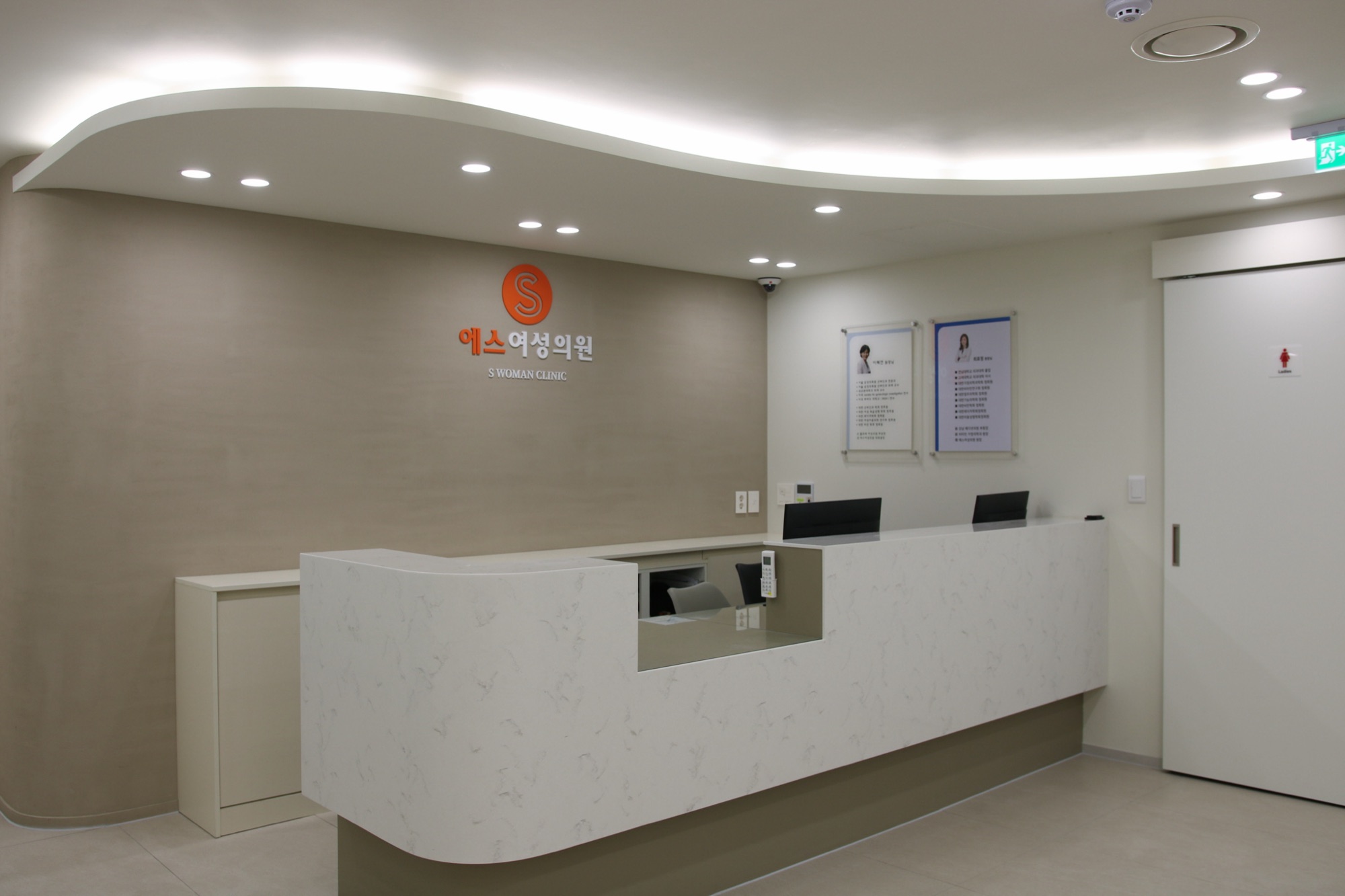 Reception desk with the clinic logo on the wall behind it