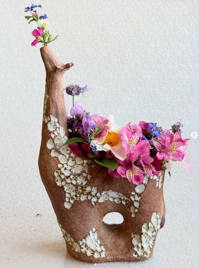 clay giraffe planter with flowers