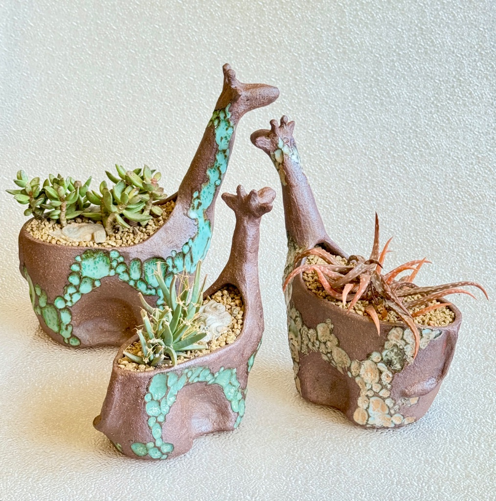 three giraffe planters