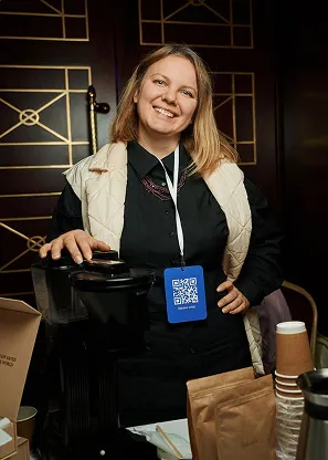 Ірина - власниця кавʼярні поклала руку на електро млинок і посміхається. Чекає поки подрібниться для замовлення