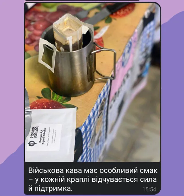 На столі стоіть металева туристична кружка з фільтром кави. Поруч лежить пакування кави
