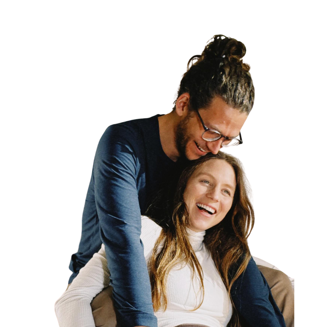 Chris leans over Jessica as they laugh together, both smiling against a plain white background.