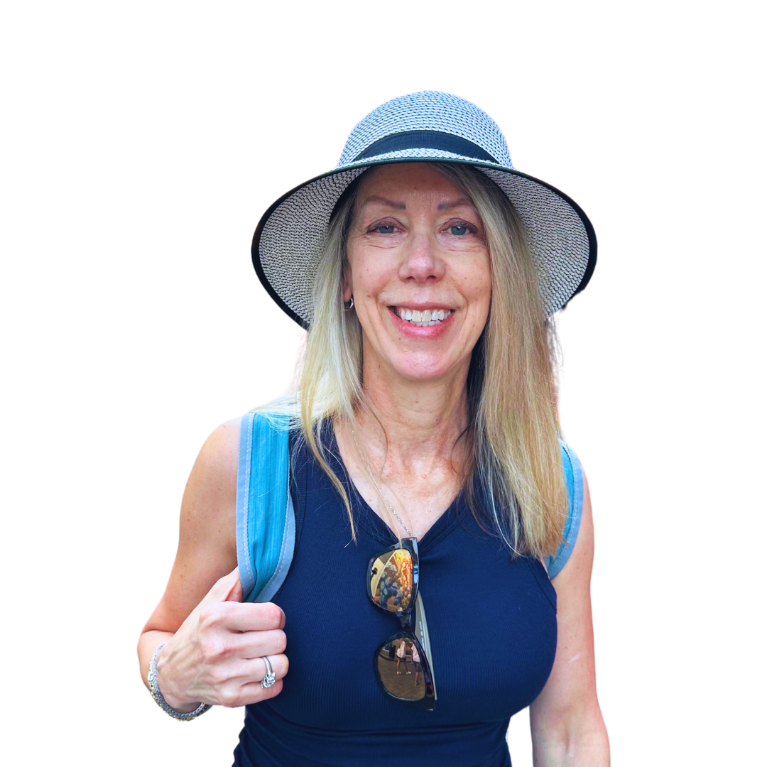 Patricia smiling in a sunhat and blue top against a soft green background.