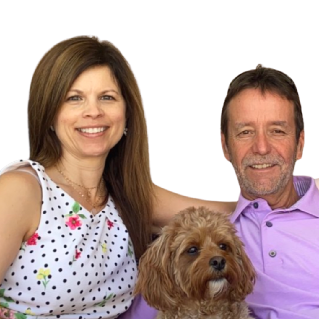 Wendy and her husband Patrick smiling together with their small brown dog.