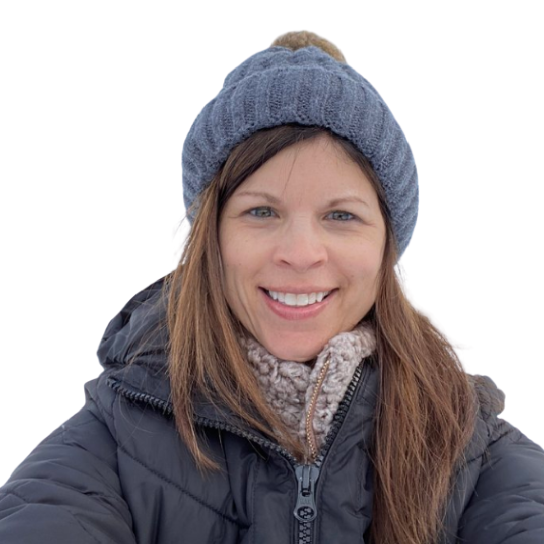 Wendy smiling in a blue knit hat, scarf and dark winter coat against a white background.