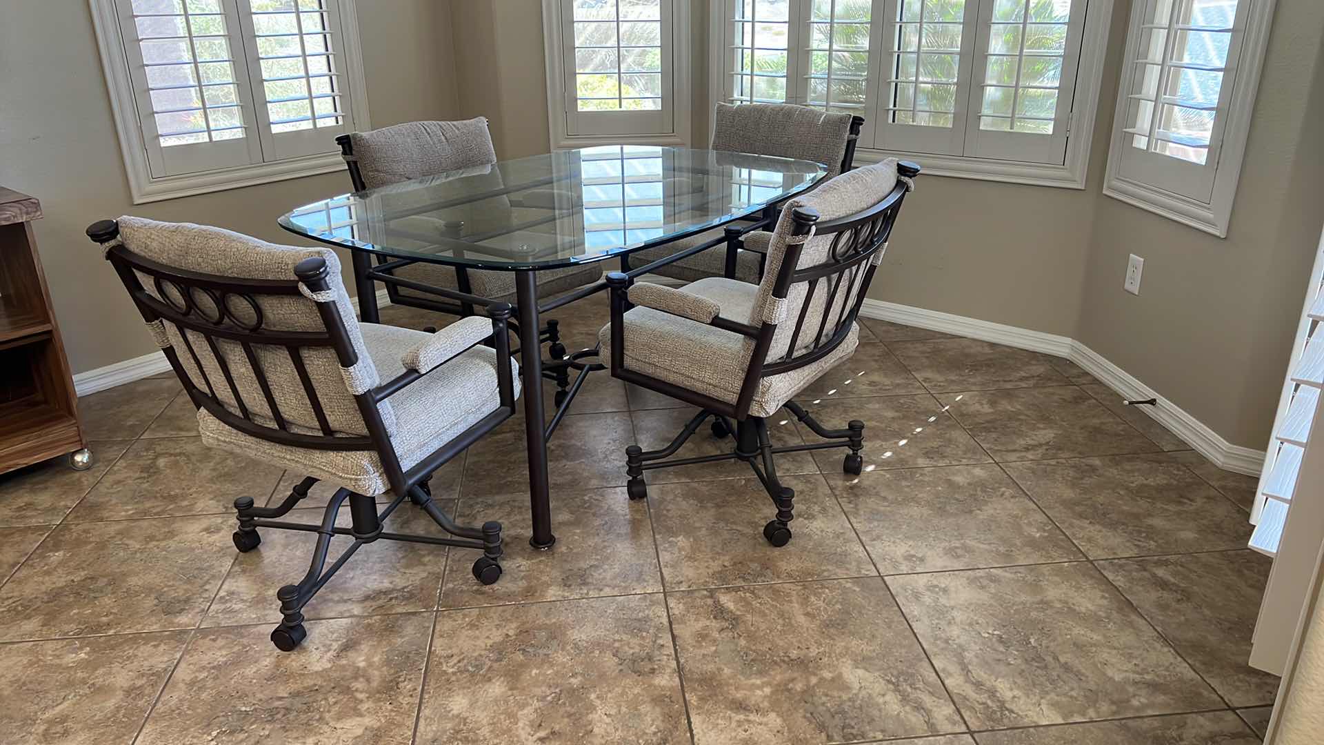 Photo 2 of WROUGHT IRON GLASSTOP TABLE W 4 WROUGHT IRON SWIVEL ROLLING CHAIRS (TABLE 50”x42” H30”)