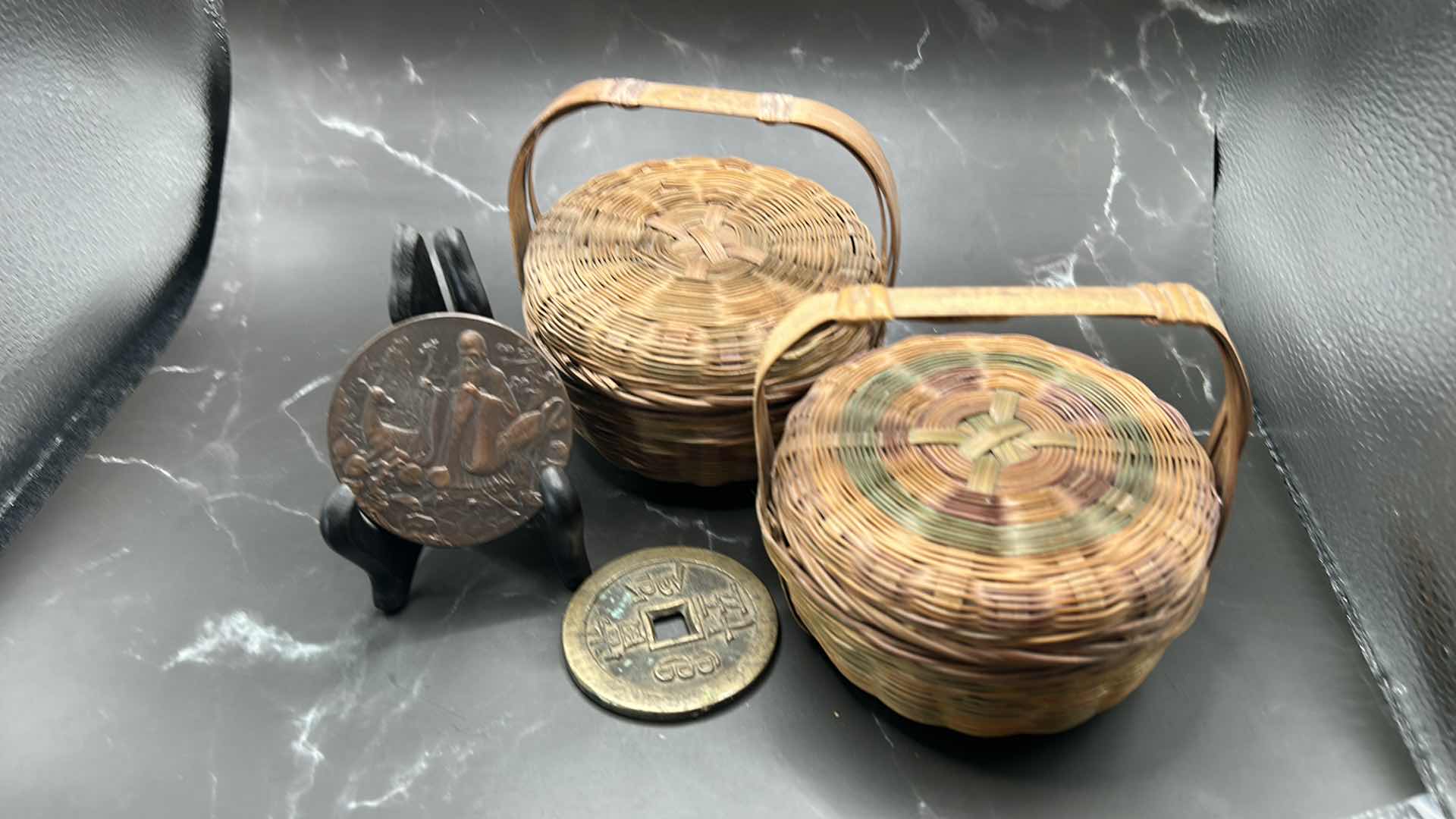 Photo 1 of 4 - PIECE CHINESE COLLECTIBLES - TWO WOVEN BASKETS AND TWO METAL COINS (LARGEST BASKET MEASURES 5” x 5”