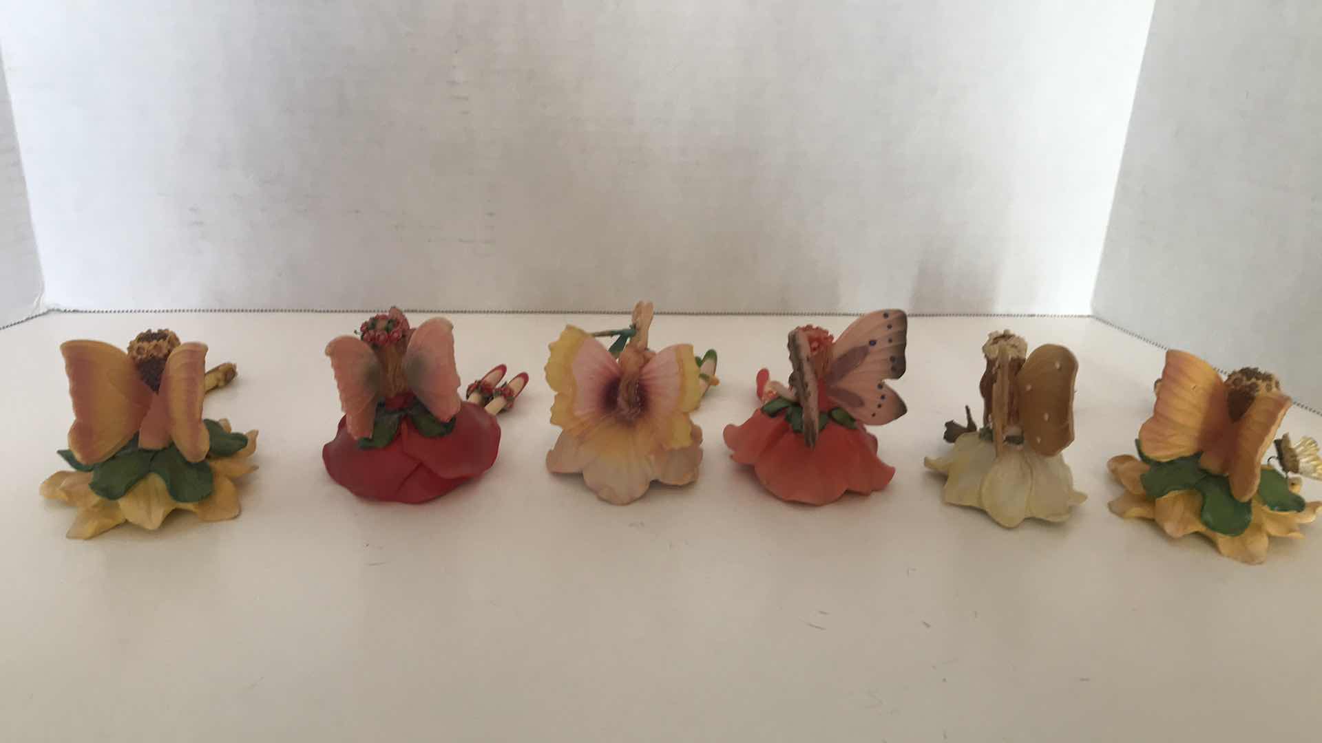 Photo 1 of COLLECTION OF SIX CERAMIC FAIRIES WITH DANGLING LEGS, APPROX 4” SITTING