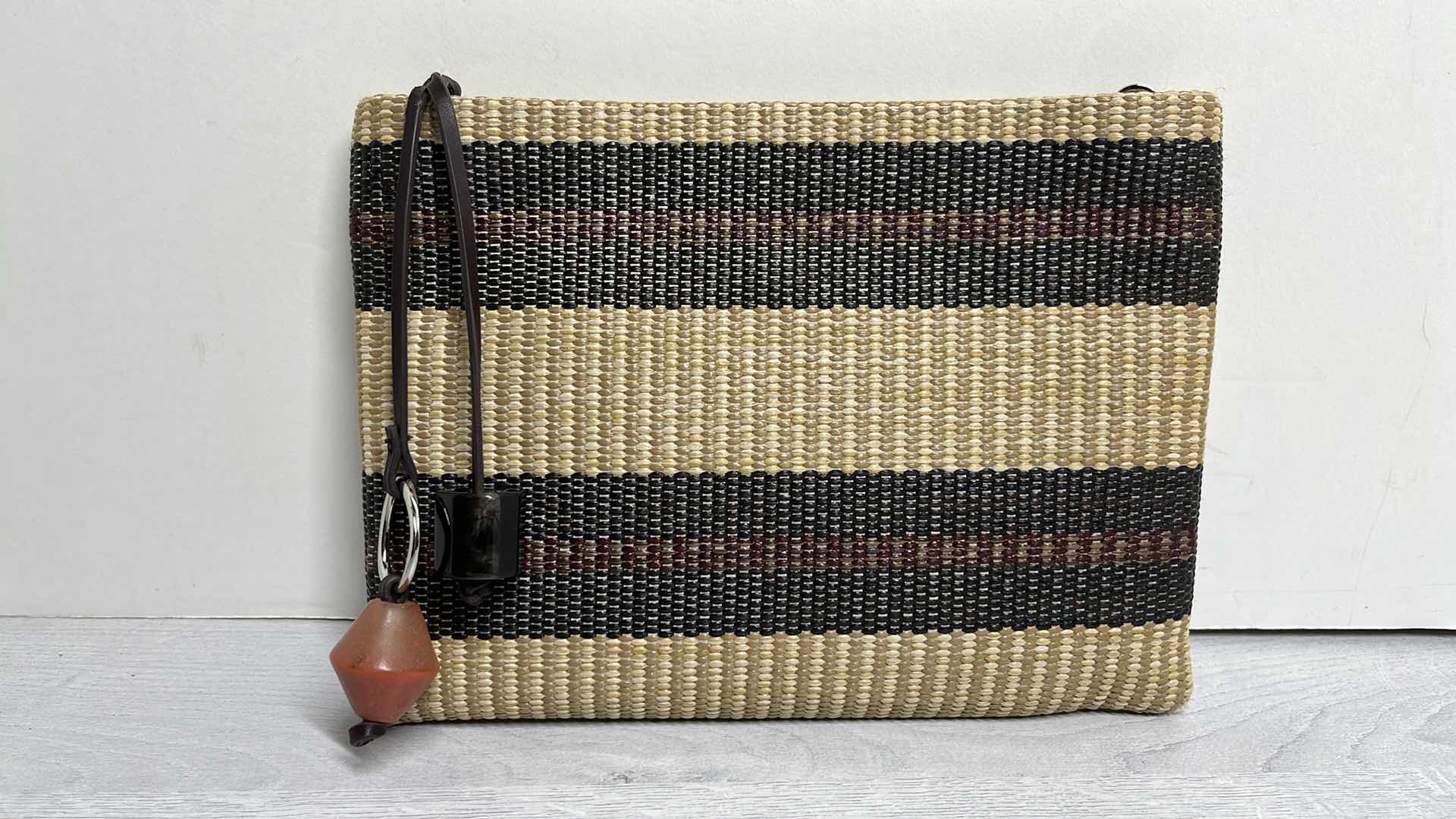 Photo 1 of ADOLFO DOMINGUEZ NATURAL RAFFIA-STYLE CLUTCH PURSE W ORNAMENTAL BAG CHARMS 10.75” X 1” H7.75”