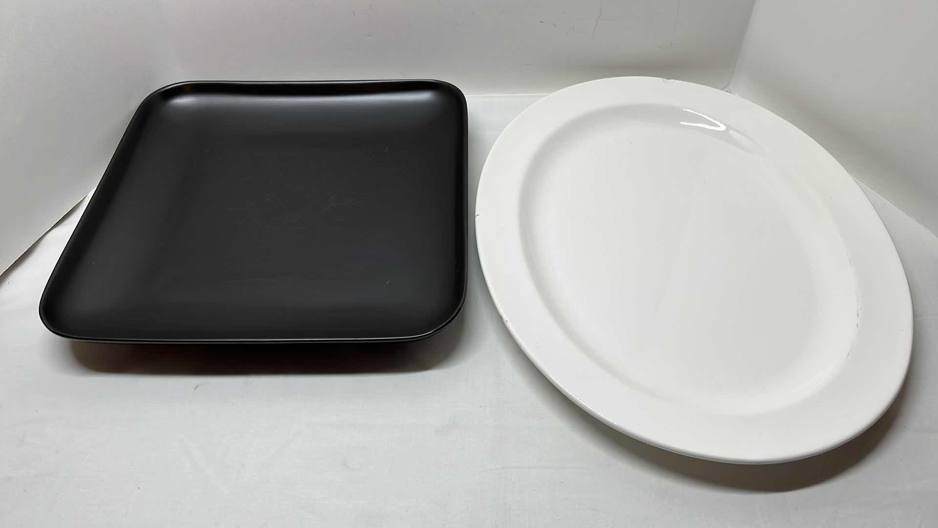 Photo 1 of 2 PCS CERAMIC SERVING PLATTERS 
BLACK 13.5” X 13.5”
WHITE 14.25” X 18”