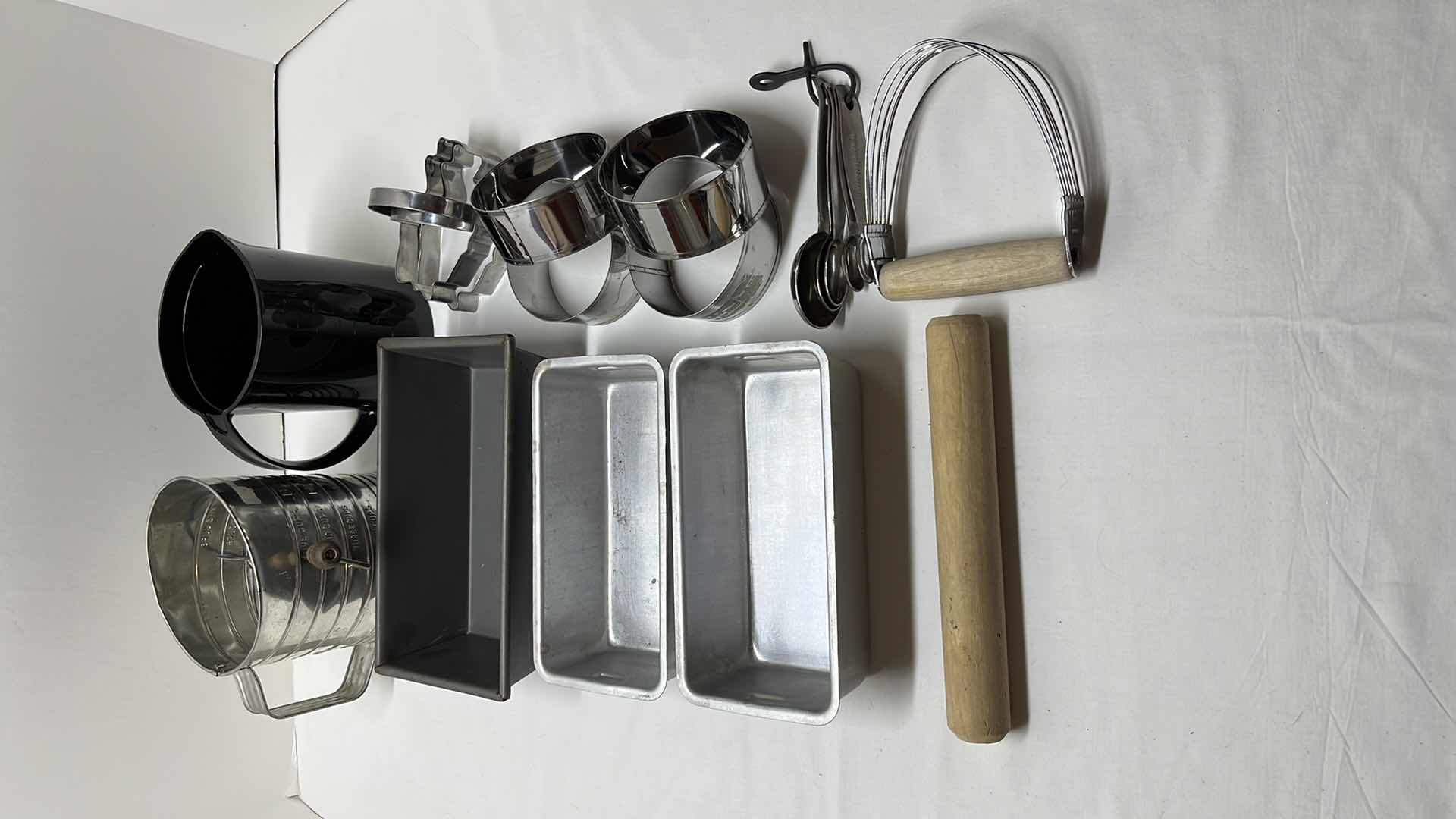 Photo 1 of LARGE MEASURING SIFTER, 35 OZ BLACK MEASURING CUP, 2 COOKIE CUTTERS, 3 LOAF PANS, (4) 3.5” ROUND DOUGH CUTTERS, MEASURING SPOON SET, ROLLING STICK AND DOUGH BLENDER