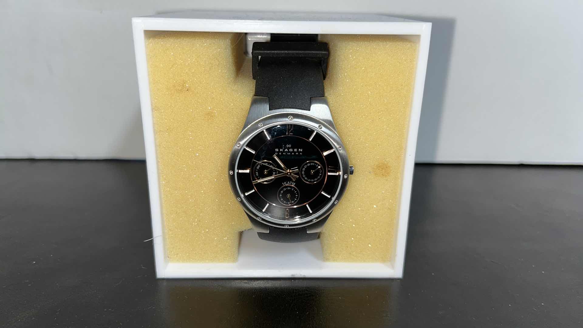 Photo 1 of MENS SKAGEN DENMARK STAINLESS STEEL CASE MULTIFUNCTION WATCH W RUBBER STRAP, BLACK DIAL W ROSE GOLD INDICATORS IN ORIGINAL BOX, MODEL 377LSRBO