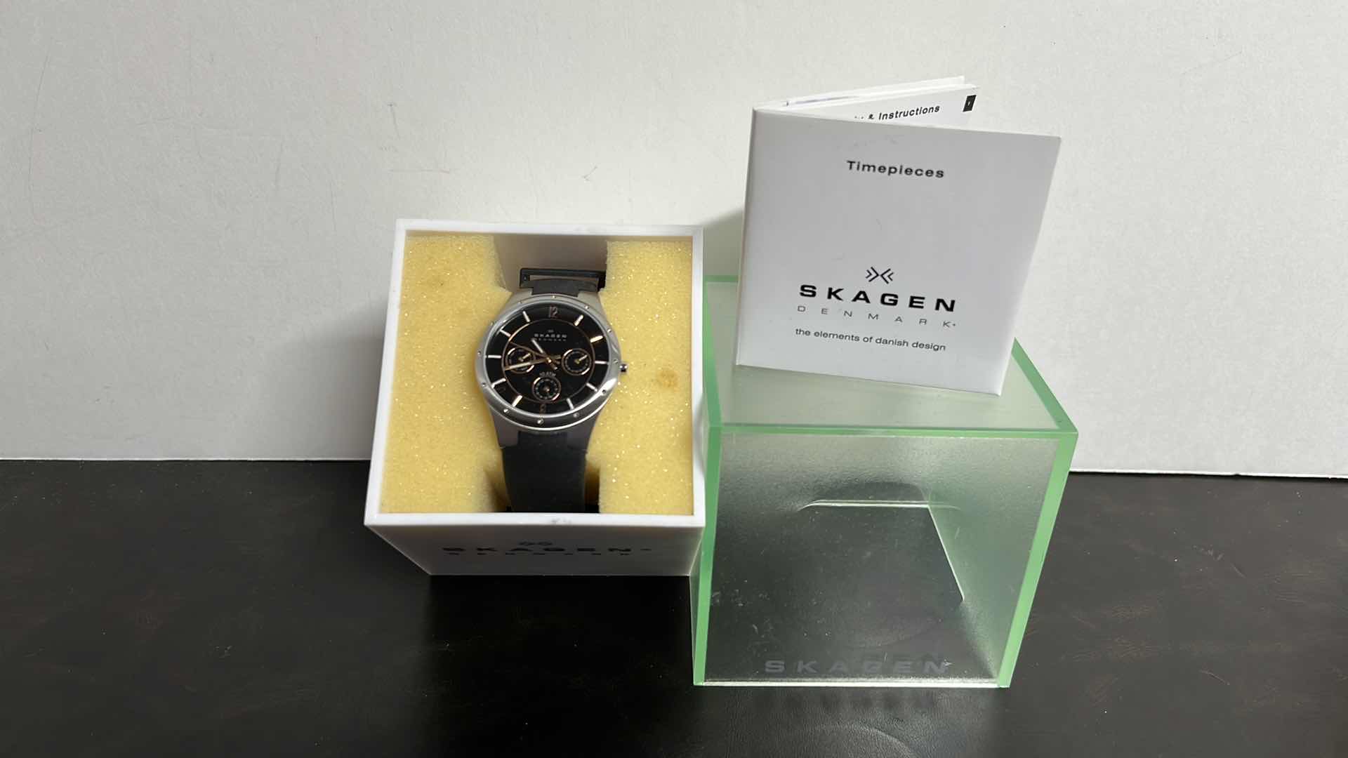 Photo 1 of MENS SKAGEN DENMARK STAINLESS STEEL CASE MULTIFUNCTION WATCH W RUBBER STRAP, BLACK DIAL W ROSE GOLD INDICATORS IN ORIGINAL BOX, MODEL 377LSRBO