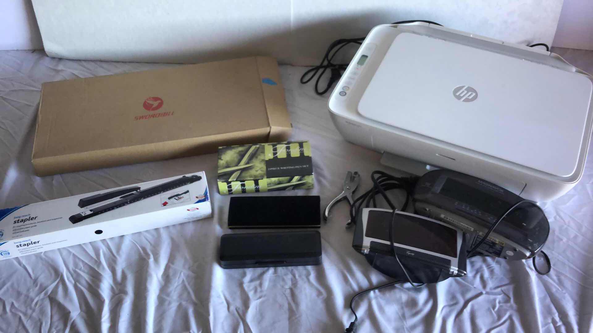 Photo 1 of OFFICE ASSORTMENT HP PRINTER, SWORDBILL WIRELESS KEYBOARD AND MOUSE, LONG STAPLER, CUSTOM PENS, ALARM CLOCK RADIOS