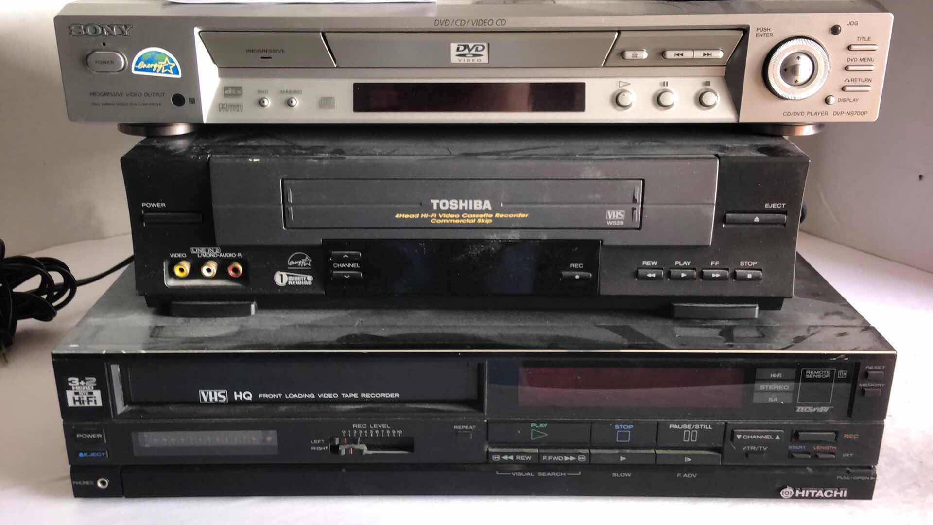Photo 1 of SONY DVD CD VIDEO PLAYER, TOSHIBA 4 HEAD HIFI VHS PLAYER AND HITACHI 3+2 HEAD HIFI VHS PLAYER W REMOTES (3)