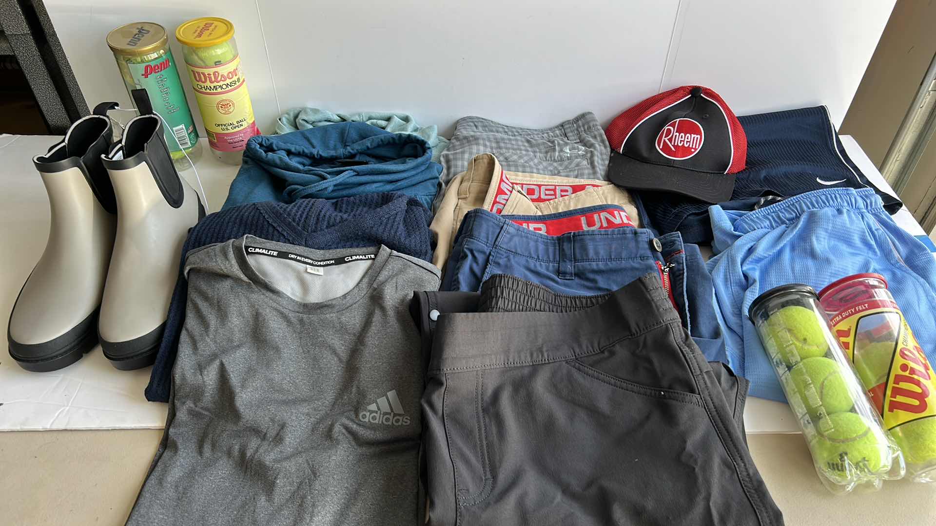 Photo 1 of MENS CLOTHING ASSORTMENT BOOTS AND TENNIS BALLS ( PANTS SHORTS MOSTLY WAIST 38”)