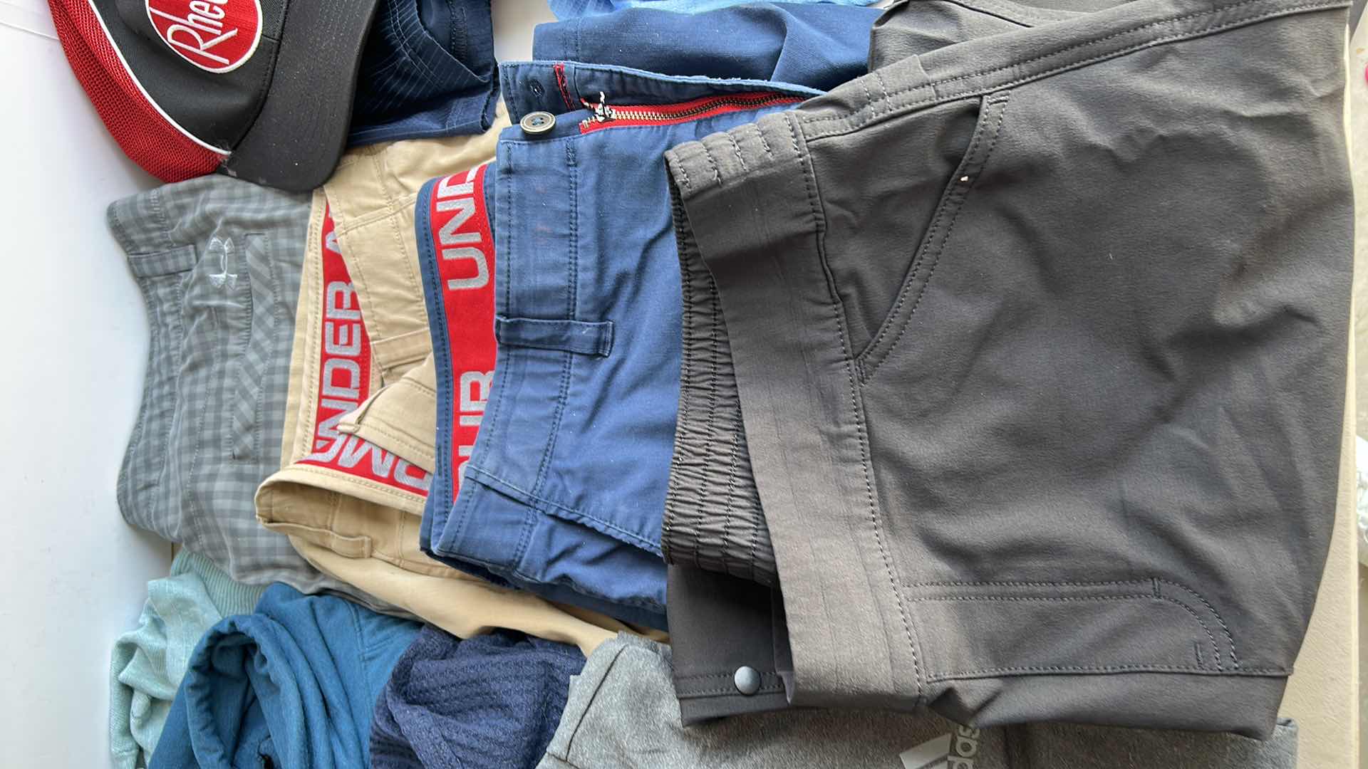 Photo 1 of MENS CLOTHING ASSORTMENT BOOTS AND TENNIS BALLS ( PANTS SHORTS MOSTLY WAIST 38”)