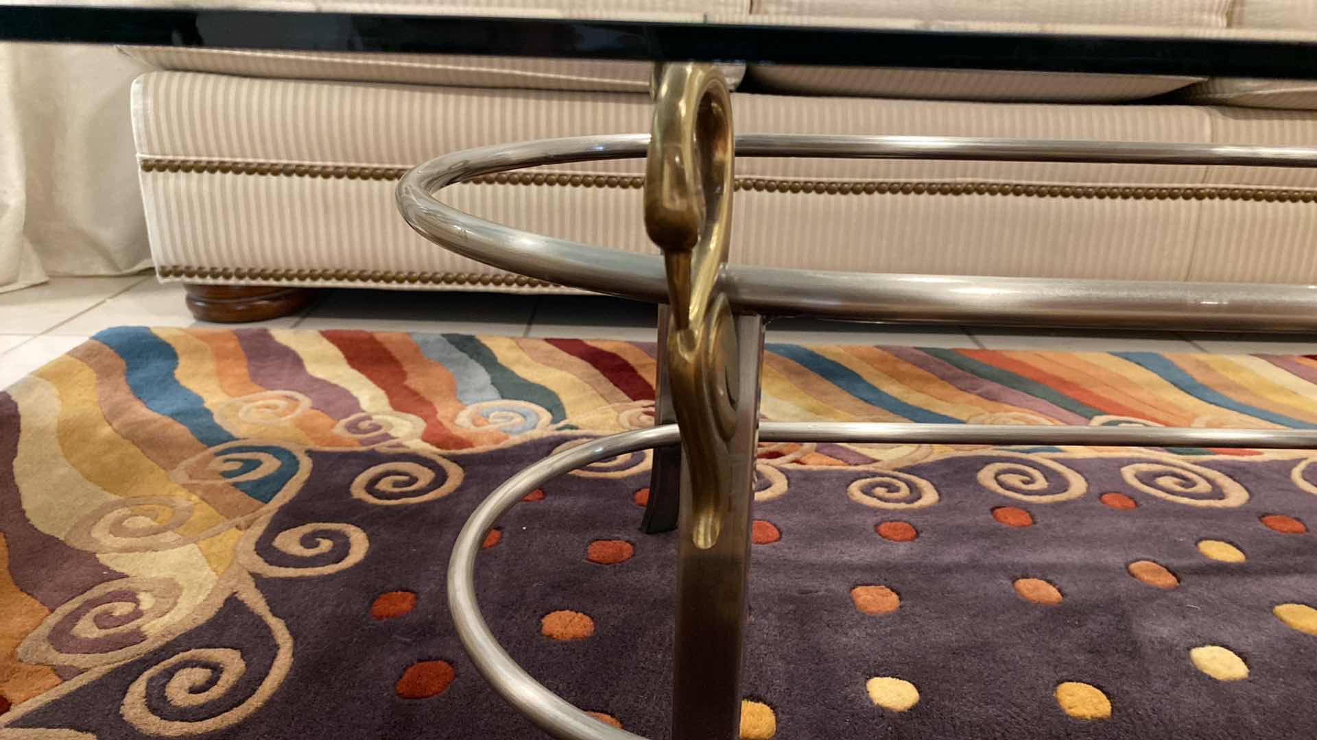 Photo 1 of BEVELED GLASS COCKTAIL TABLE WITH SILVER AND GOLD HEAVY METAL BASE WITH SWAN DETAIL 52”X 24”