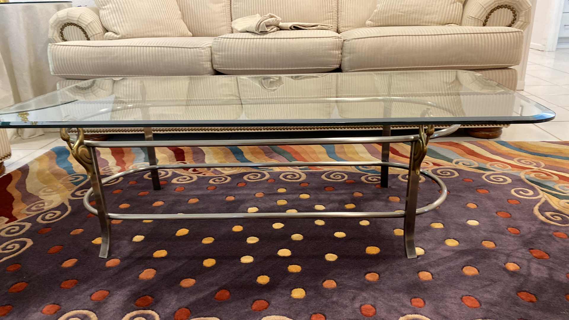 Photo 1 of BEVELED GLASS COCKTAIL TABLE WITH SILVER AND GOLD HEAVY METAL BASE WITH SWAN DETAIL 52”X 24”