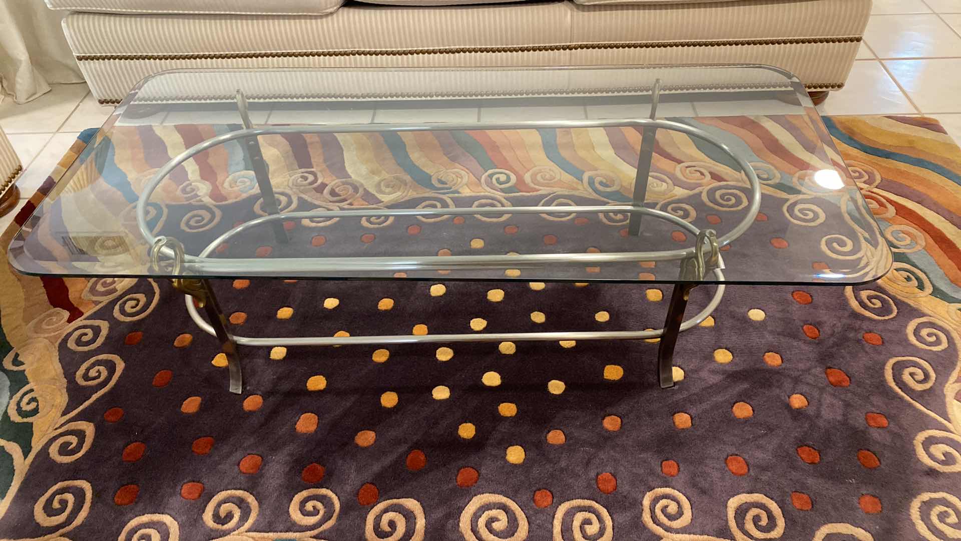 Photo 1 of BEVELED GLASS COCKTAIL TABLE WITH SILVER AND GOLD HEAVY METAL BASE WITH SWAN DETAIL 52”X 24”