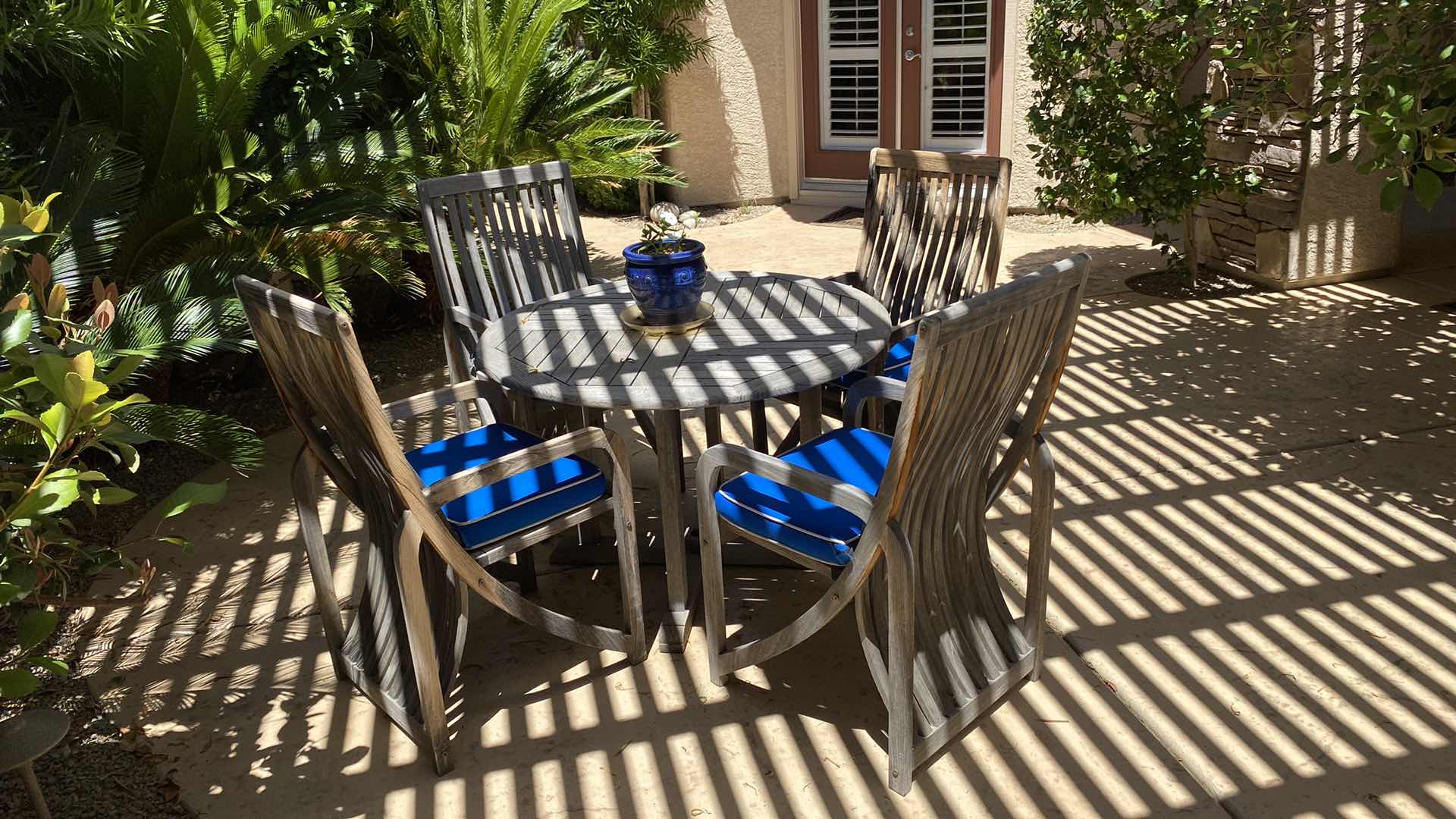 Photo 1 of TEAK WAREHOUSE DINING SET WITH 4 CHAIRS MARINE BLUE WATER REPELLANT AND SUN PROTECTION FABRIC AND POTTED PLANT - TABLE 43” H29” 