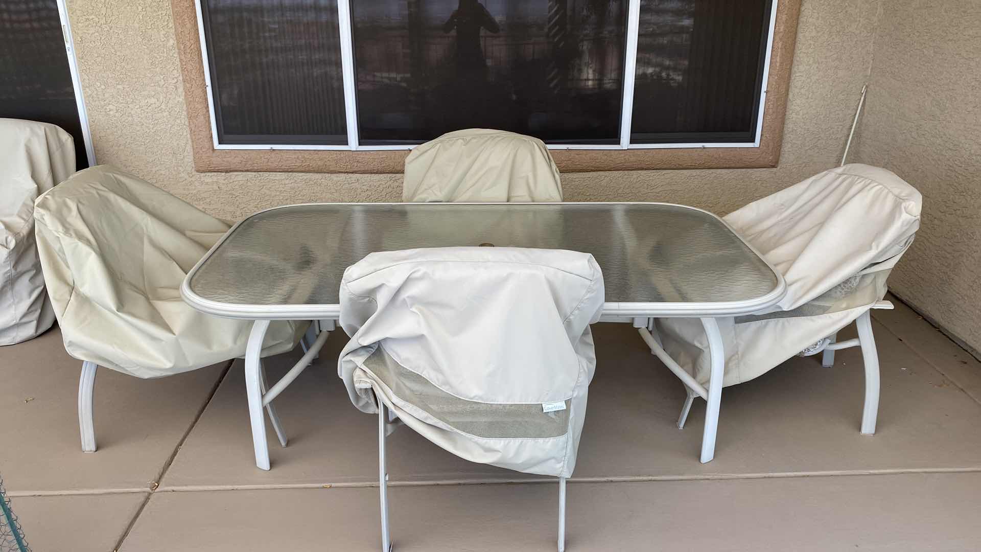 Photo 1 of ALUMINUM TABLE WITH GLASS TOP 78“ x 43“ x 27“ high AND 4 CHAIRS WITH COVERS