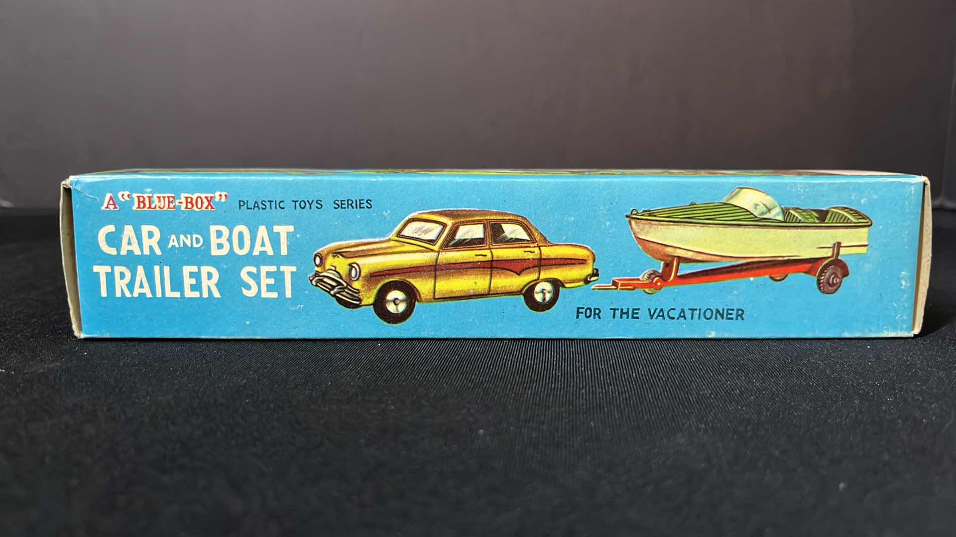 Photo 1 of A BLUE BOX PLASTIC TOY SERIES CAR AND BOAT TRAILER SET, FOR THE VACATIONER