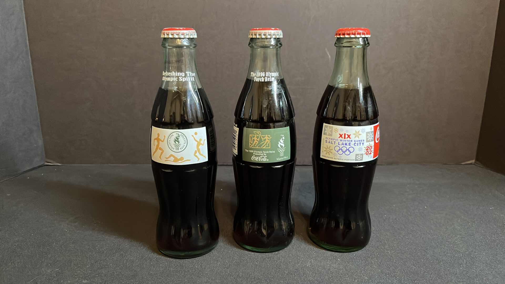 Photo 1 of COCA-COLA 3-COMMEMORATIVE OLYMPICS 8 OZ BOTTLES, ATLANTA 1996 OLYMPICS, ATLANTA 1996 TORCH RELAY & SALT LAKE CITY 2002, UNOPENED