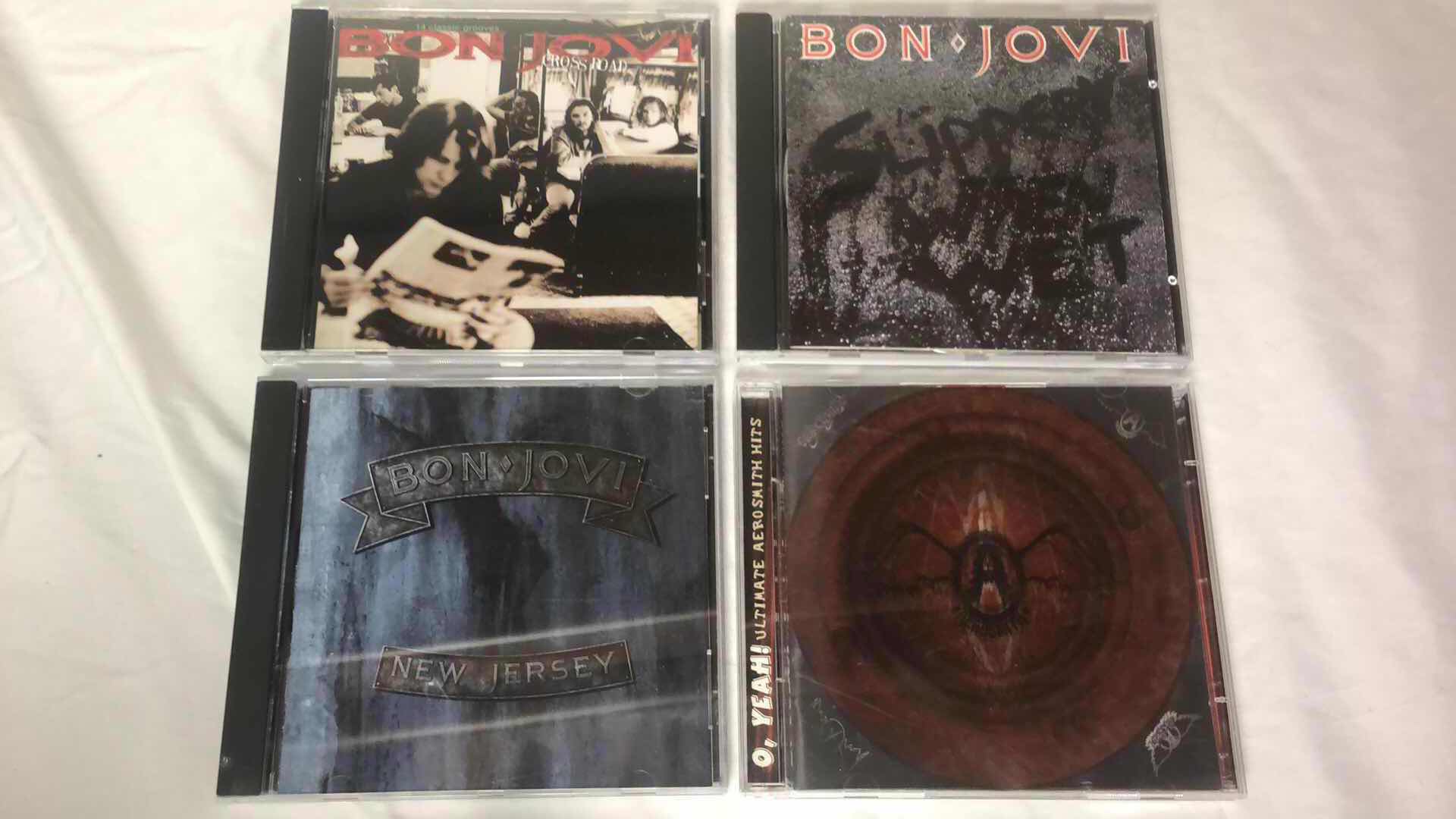 Photo 1 of ASSORTMENT OF BON JOVI AND AEROSMITH ALBUM CDS (4)