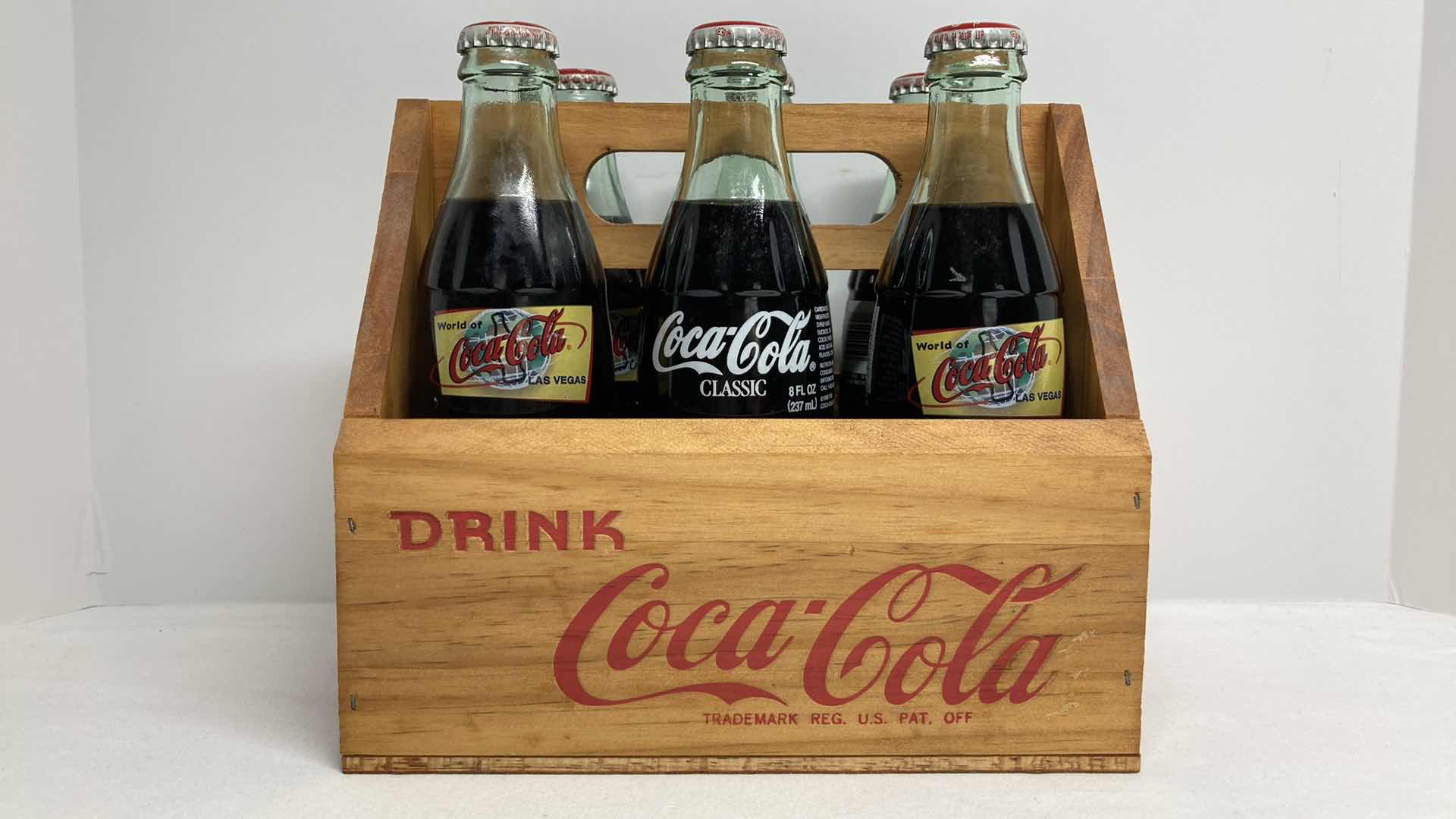 Photo 1 of COCA-COLA WORLD COCA-COLA LAS VEGAS GLASS SEALED BOTTLES (6) W WOOD CARRIER