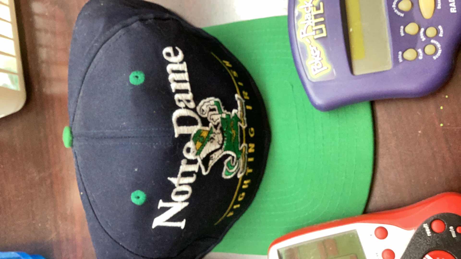 Photo 1 of 2 NOTRE DAMN FOOTBALL CAPS AND HANDHELD GAMES