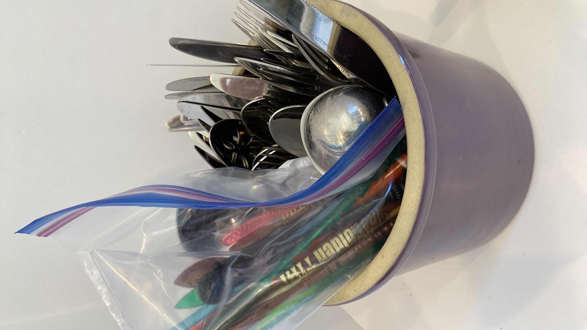 Photo 2 of CONTENTS OF KITCHEN CABINET
 PURPLE CROCK WITH SILVERWARE AND CERAMIC ASPARAGUS DECOR