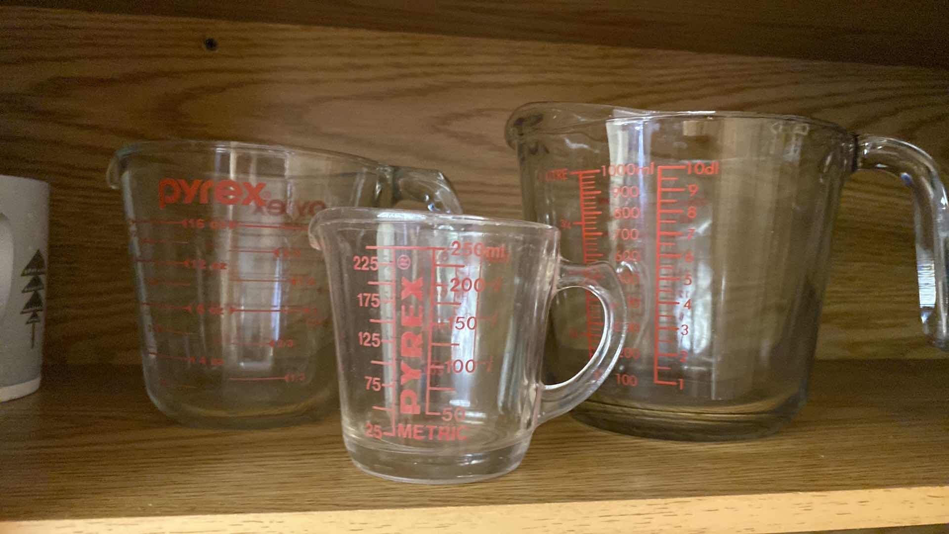 Photo 1 of CONTENTS OF KITCHEN CABINET PYREX MEASURING CUPS AND MORE