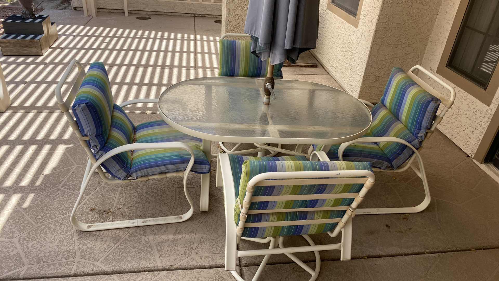 Photo 1 of ALUMINUM PATIO TABLE  54“ x 35“ H 27 1/2 “WITH GLASS TOP AND 4 CHAIRS AND UMBRELLA