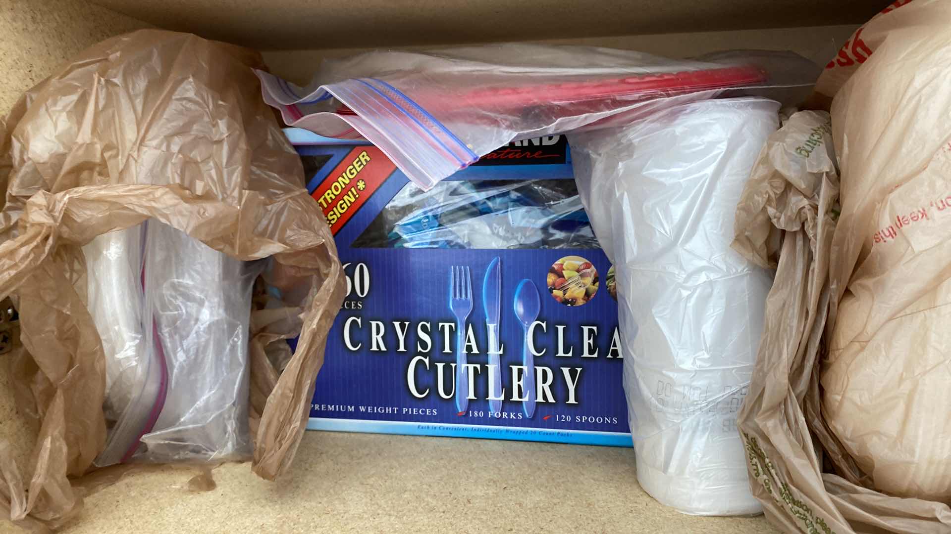 Photo 1 of 2 SHELVES OF PAPER GOODS SILVERWARE TRASH BAGS IN GARAGE