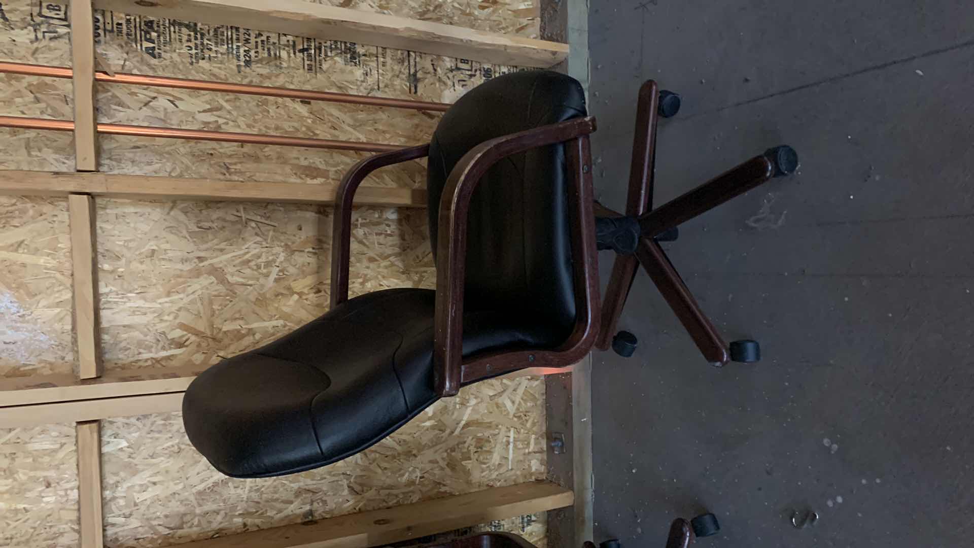 Photo 1 of BLACK WOOD AND BONDED LEATHER OFFICE CHAIR ON WHEELS