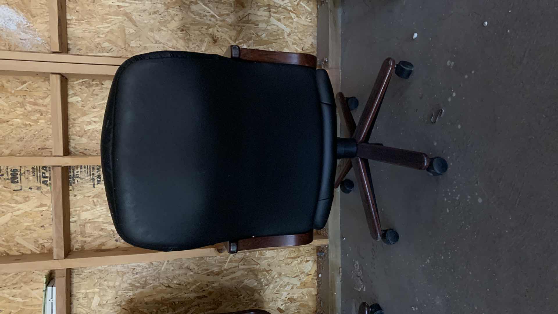 Photo 1 of BLACK WOOD AND BONDED LEATHER OFFICE CHAIR ON WHEELS