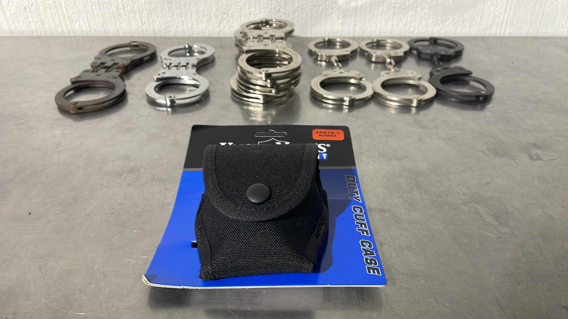 Photo 1 of HEAVYDUTY LAW ENFORCEMENT CUFF CASE WITH 9 SETS OF HAND CUFFS 6 OF THE 9 ARE PEERLESS. NO KEYS
