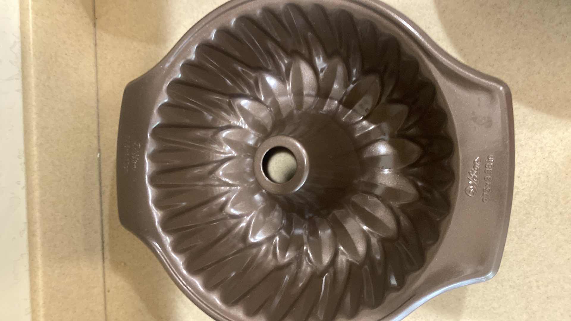 Photo 1 of CONTENTS OF KITCHEN CABINET- 3 BUNDT PANS