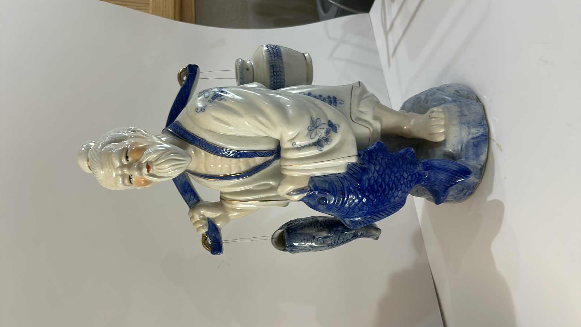 Photo 1 of VINTAGE BLUE & WHITE ASIAN PORCELAIN FISHERMAN FIGURINE DETAILED HAND-PAINTED FIGURE WITH FISH & HANGING VESSEL ESTIMATED RETAIL VALUE:$125 H16”